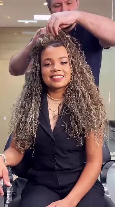 Profissional finalizando cachos no salão